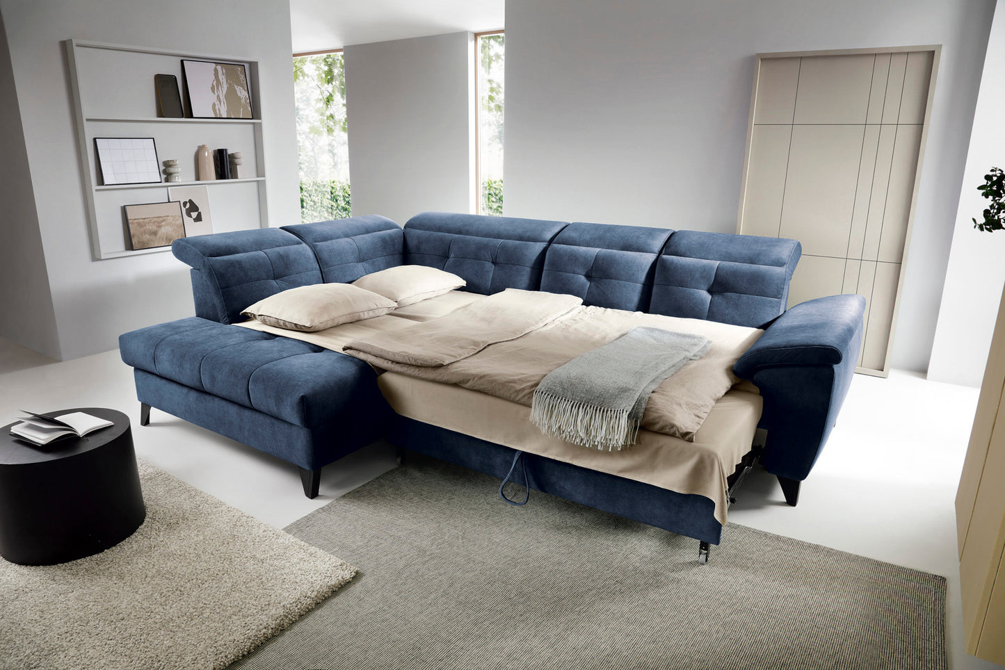 Narożnik Inferne Aura 40 zgaszony niebieski w układzie lewym rozłożony jako łóżko z widoczną ramą i pościelą.