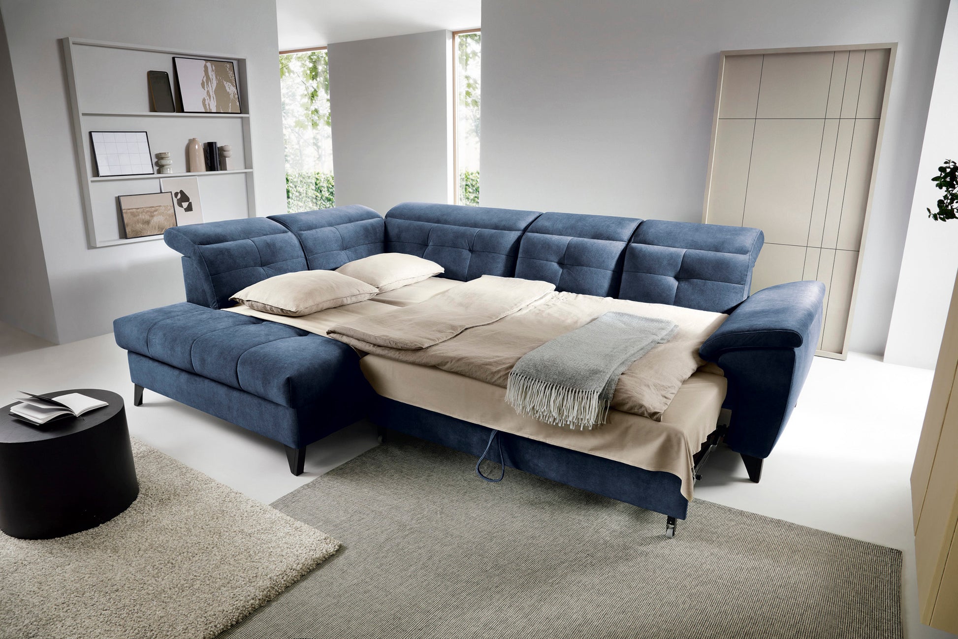 Narożnik Inferne Aura 40 zgaszony niebieski w układzie lewym rozłożony jako łóżko z widoczną ramą i pościelą.