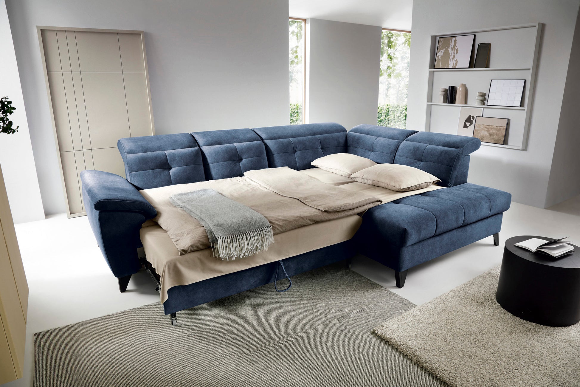 Narożnik Inferne Aura 40 zgaszony niebieski w układzie prawym rozłożony jako łóżko z widoczną ramą i pościelą.