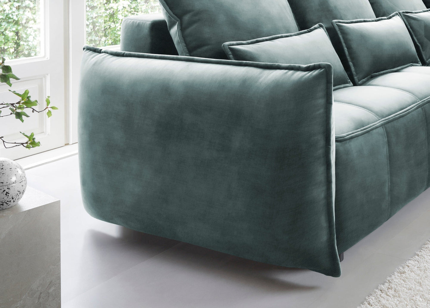 Detal prawego podłokietnika narożnika Campo w kolorze Manhattan 38 zielony, podkreślający zaokrąglony profil i strukturę tapicerki.