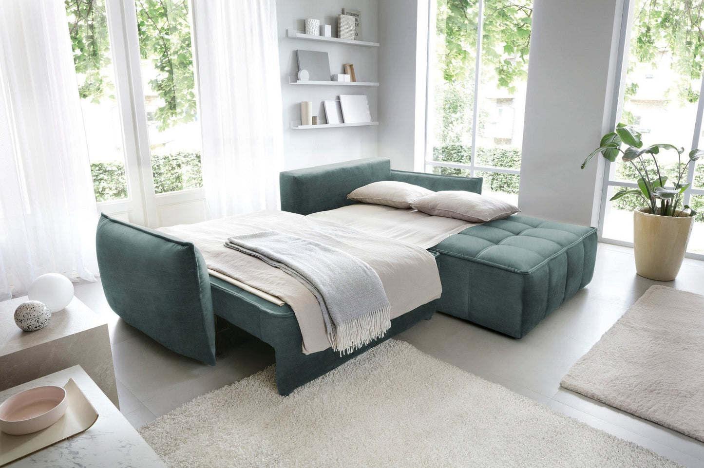 Narożnik Campo w kolorze Manhattan 38 zielony w układzie prawym rozłożony na łóżko, z rozciągniętą narzutą i dwoma poduszkami.