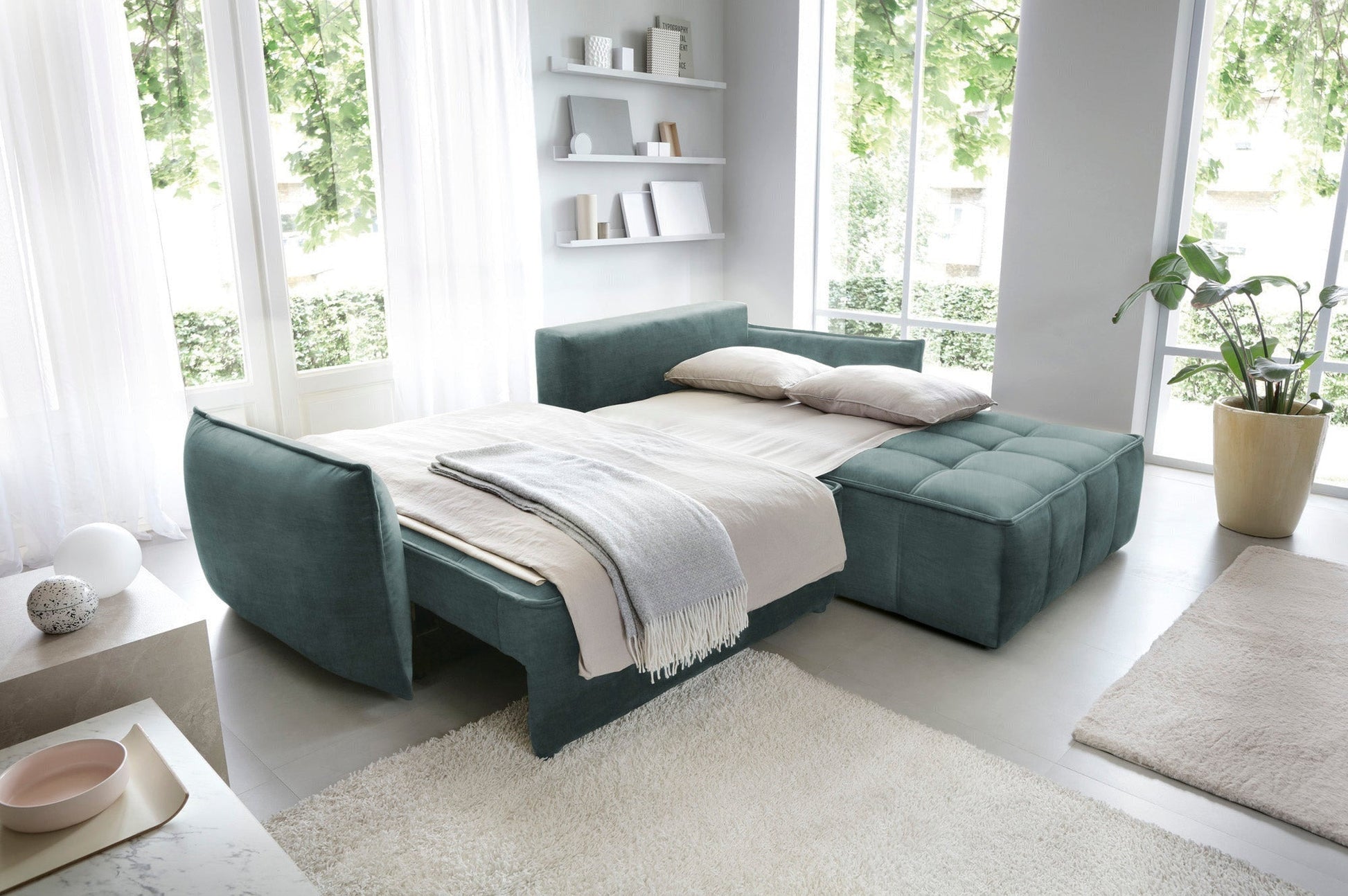 Narożnik Campo w kolorze Manhattan 38 zielony w układzie prawym rozłożony na łóżko, z rozciągniętą narzutą i dwoma poduszkami.