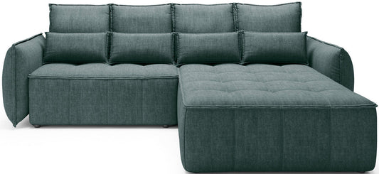 Narożnik Campo w układzie prawym obity tkaniną Manhattan 38 zielony, widok z przodu na białym tle z pikowanym szezlongiem po prawej stronie.