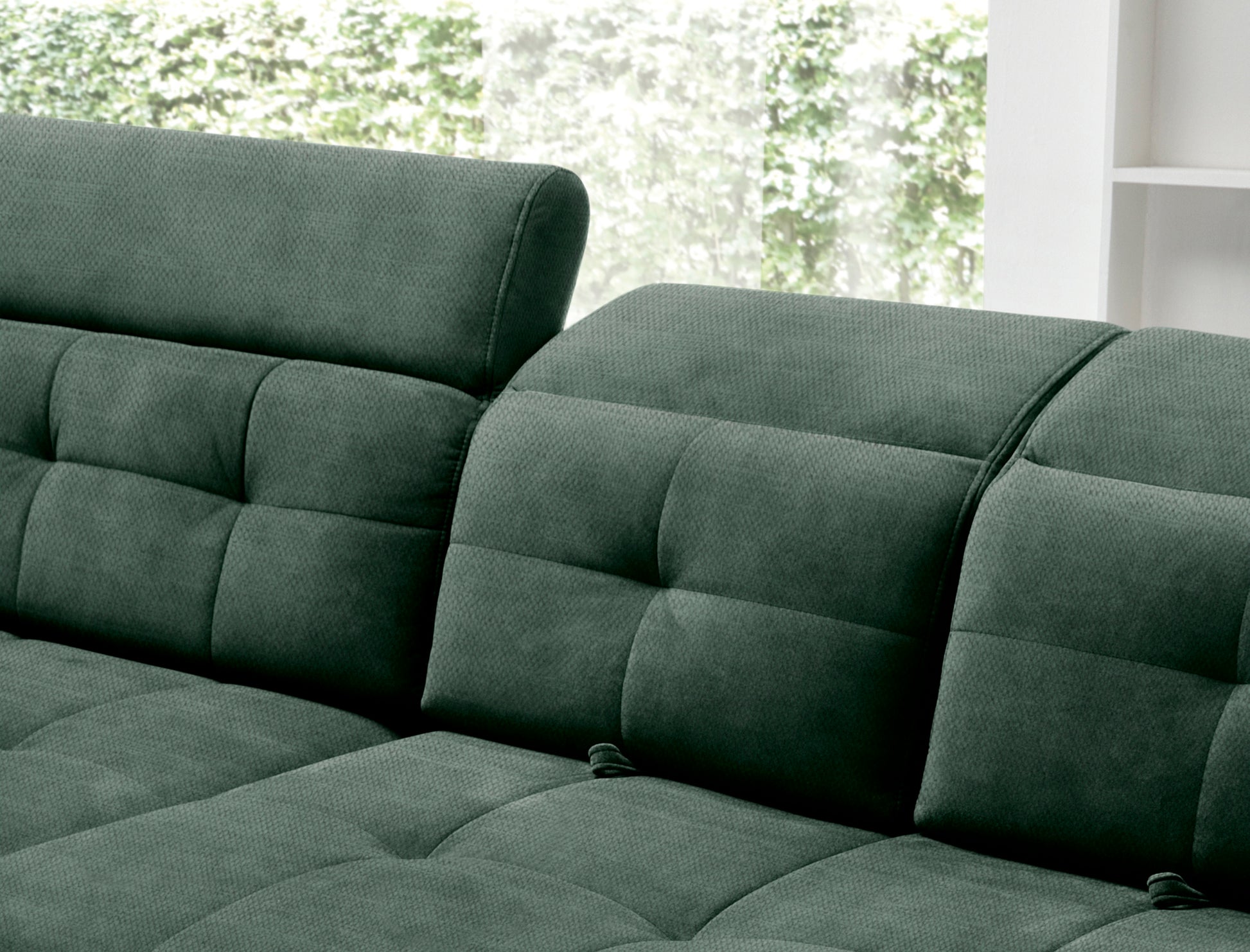 Zbliżenie na pikowane siedzisko oraz profilowany podłokietnik narożnika Inferne Raquel 35 zielonego w układzie lewym.