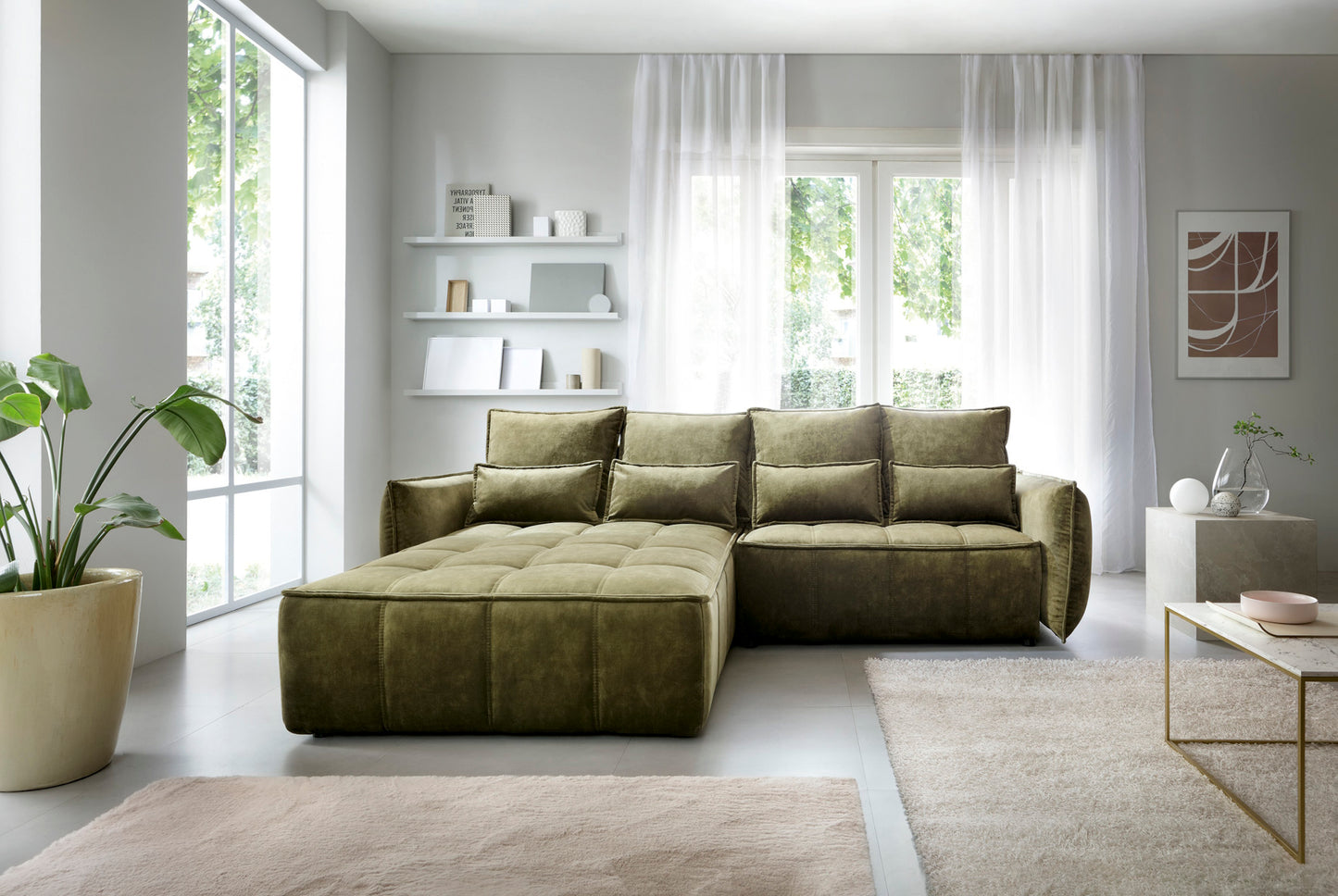 Narożnik Campo Toscana 33 zielony w układzie lewym w jasnym salonie przy dużym oknie z białymi zasłonami i minimalistycznymi półkami.