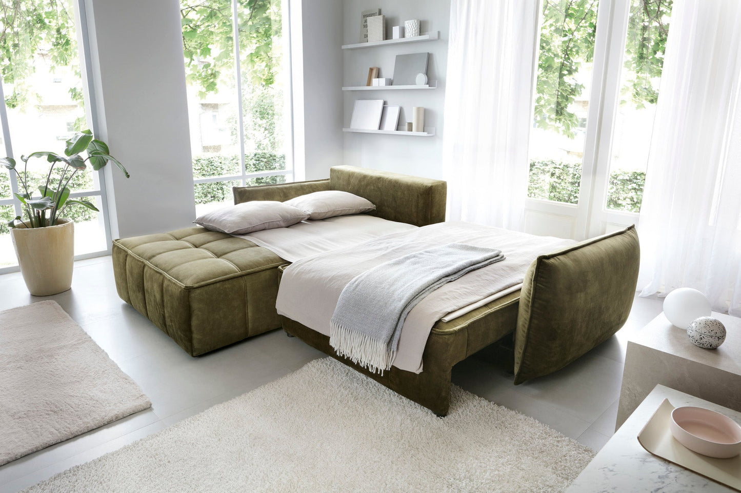 Narożnik Campo Toscana 33 zielony w układzie lewym przekształcony w funkcjonalne łóżko – rozsunięte siedzisko i nałożona pościel w pokoju dziennym.