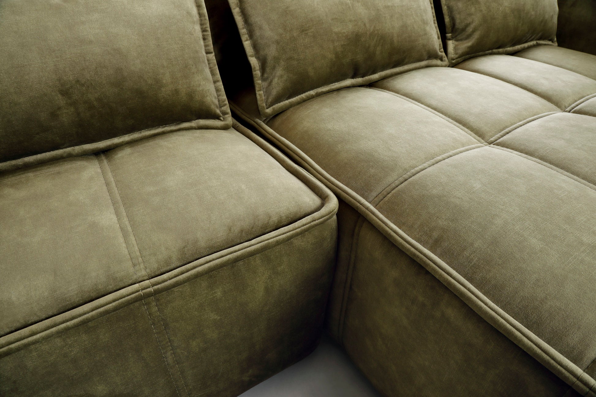 Zbliżenie pikowanego siedziska narożnika Campo Toscana 33 zielonego w układzie prawym, eksponujące równomierne przeszycia i aksamitną tkaninę.