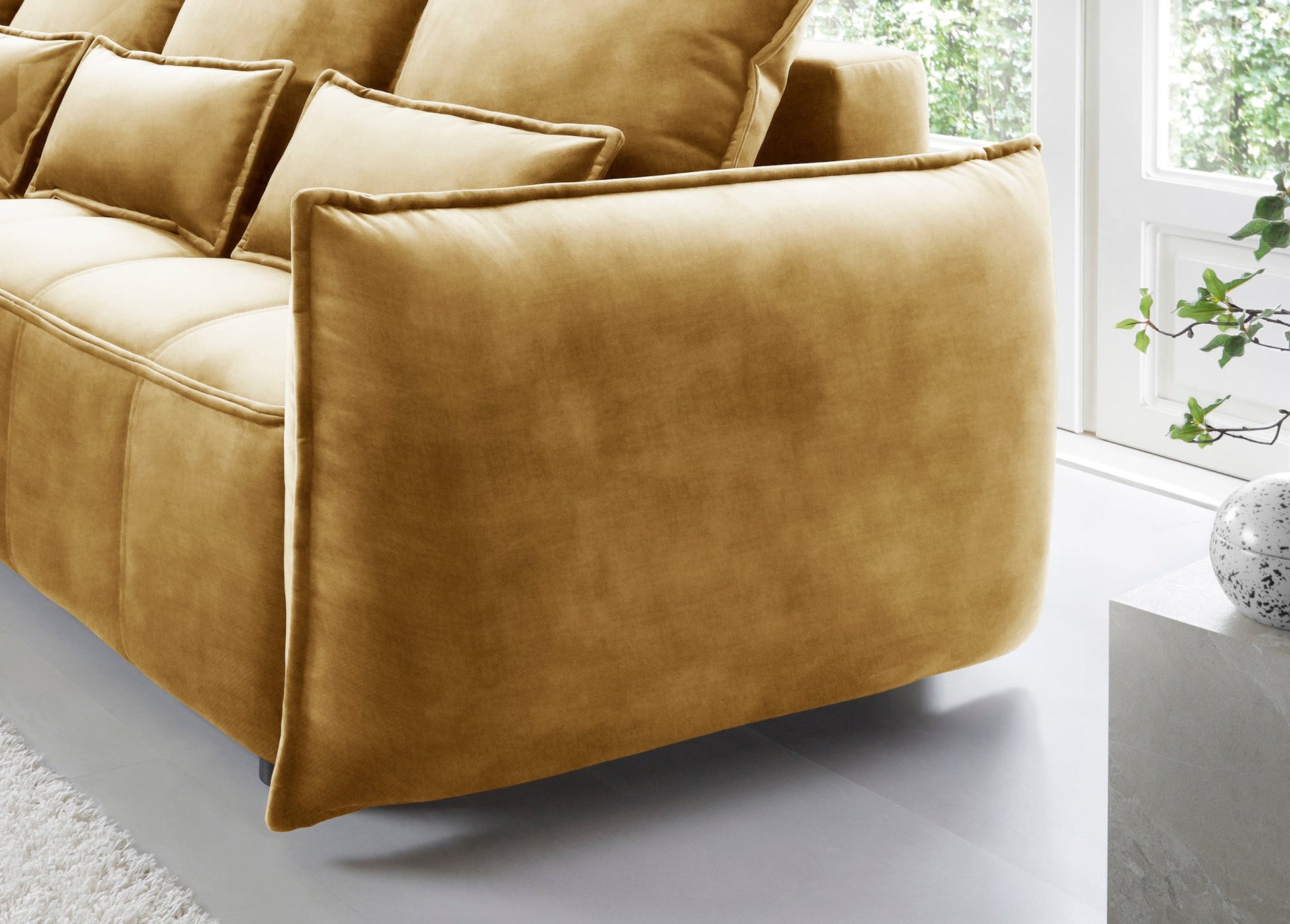 Narożnik Campo w układzie lewym – zbliżenie na pikowaną powierzchnię siedziska i dopasowane poduszki w tkaninie Manhattan 45.