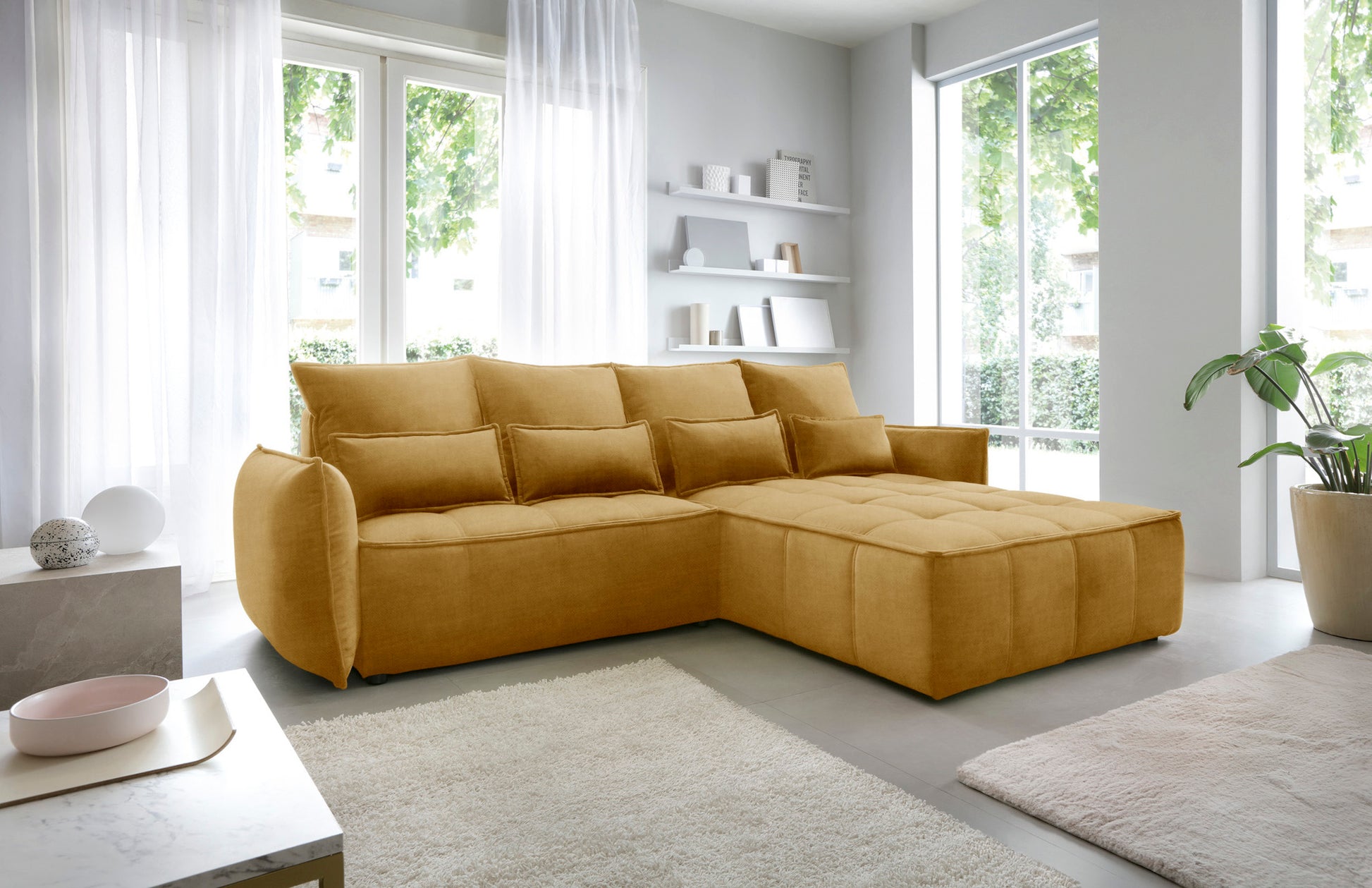 Narożnik Campo w układzie prawym, Manhattan 45 żółty, widok z boku w nowoczesnym wnętrzu z minimalistycznymi regałami i dywanem.