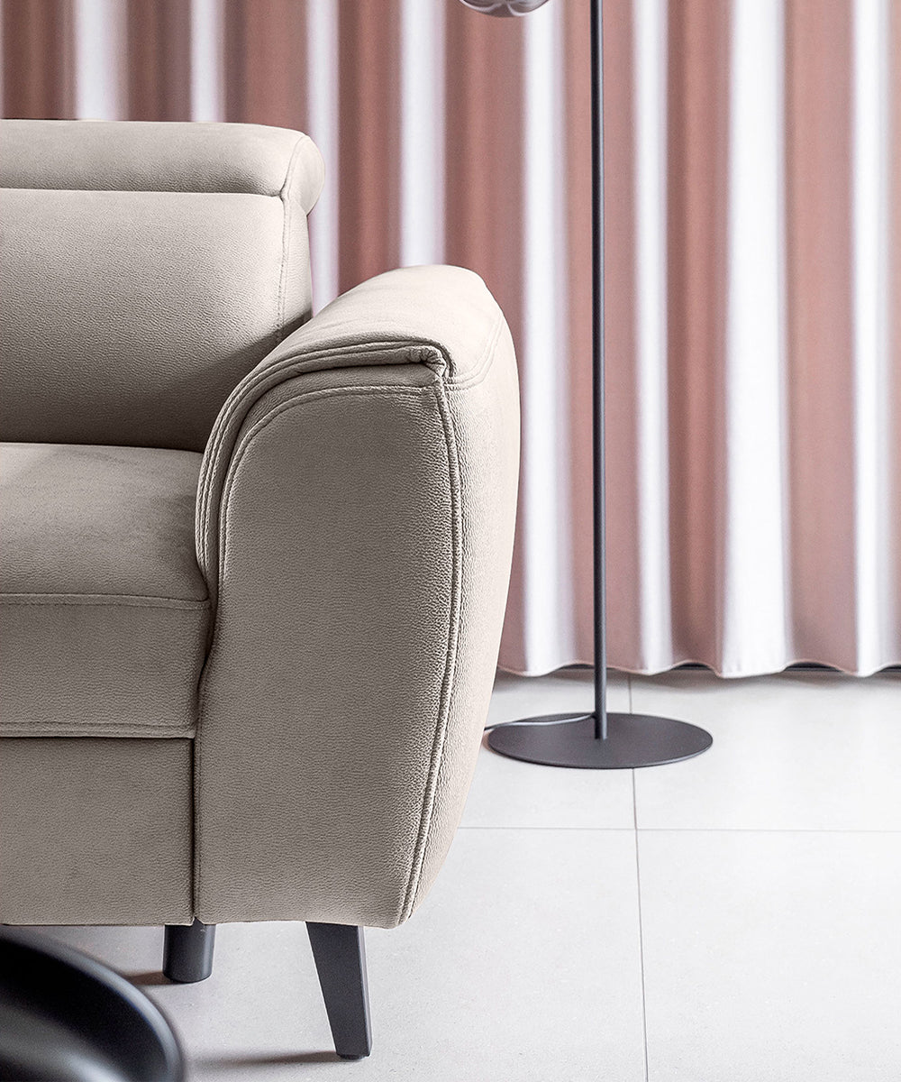 Fragment narożnika Noble w jasnoszarej tkaninie Loco 04 z dekoracyjnymi przeszyciami i subtelną strukturą materiału. Elegancki narożnik do salonu inspirowanego stylem japandi, soft loft i contemporary.
