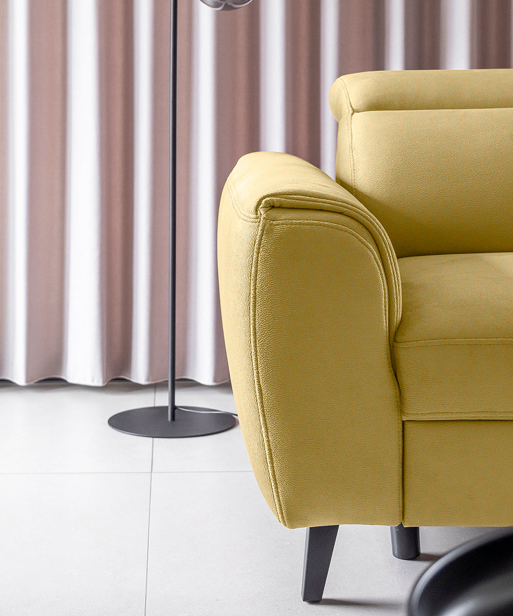 Fragment narożnika Noble w musztardowej tkaninie Savoi 45 z eleganckim wykończeniem tapicerki i wysokimi metalowymi nóżkami. Nowoczesny narożnik do salonu zapewniający lekki wygląd oraz komfort użytkowania.