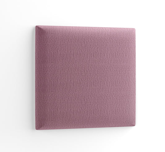 Kwadratowy panel tapicerowany Quadratta I Monolith 63 w pastelowym różowym odcieniu, przedstawiony w delikatnym, ukośnym ujęciu na białym tle, eksponujący miękką fakturę tkaniny.