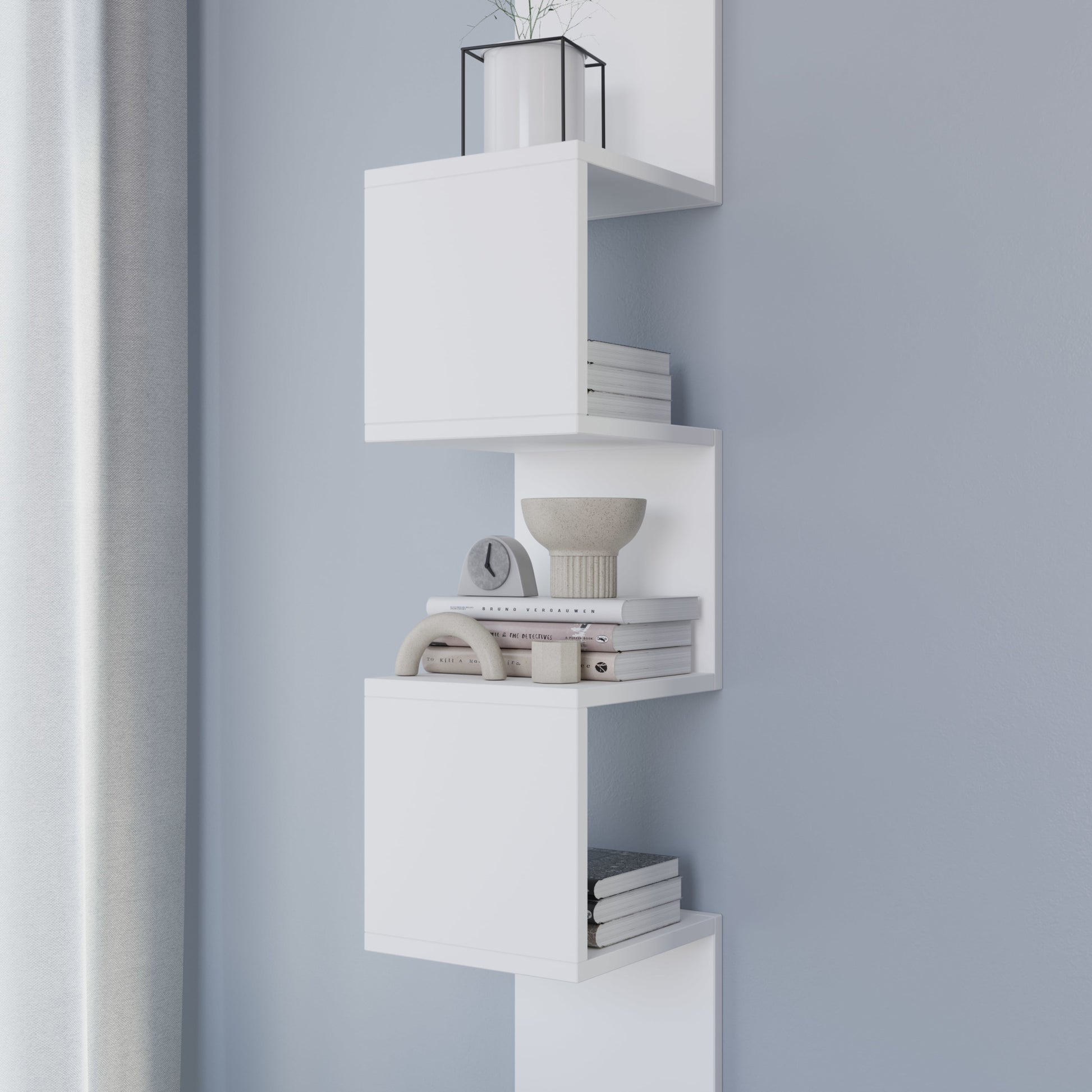 Detal środkowych modułów białej półki Sunpedo wypełnionych książkami i ceramiczną miską, ukazujący matową fakturę.