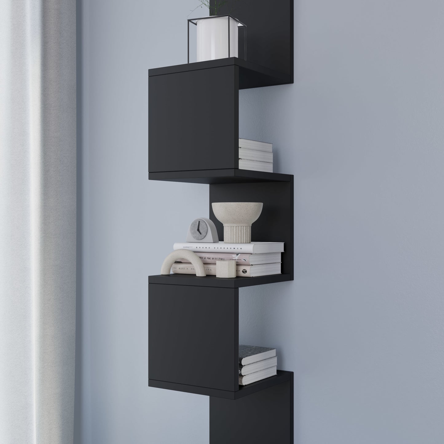 Zbliżenie środkowych modułów czarnej półki Sunpedo wypełnionych książkami i dekoracyjną miską, ukazujące matową fakturę.