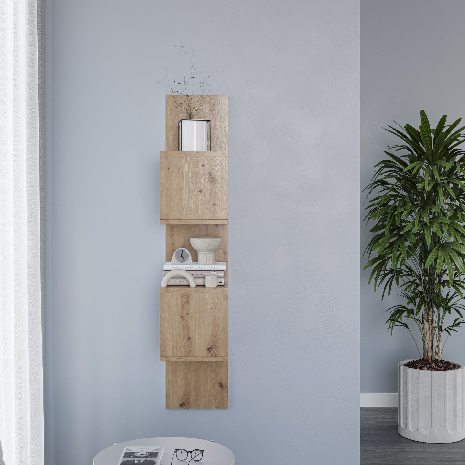 Pionowa półka Sunpedo dąb artisan zamontowana na jasnoniebieskiej ścianie, z białą doniczką na najwyższym module i dużą rośliną doniczkową obok.