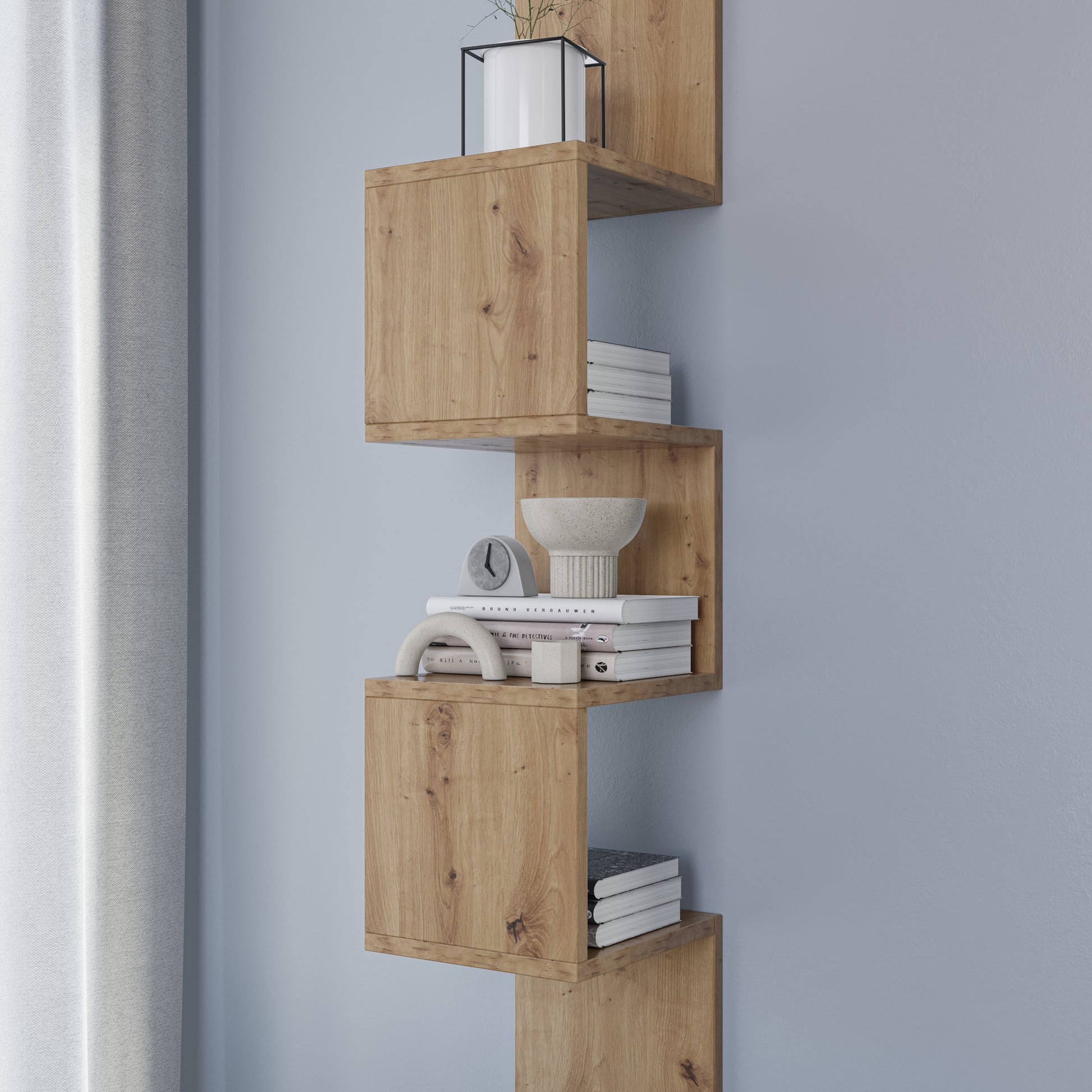 Detal środkowych modułów półki Sunpedo dąb artisan wypełnionych książkami i ceramiczną miską, eksponujący naturalne usłojenie drewna.