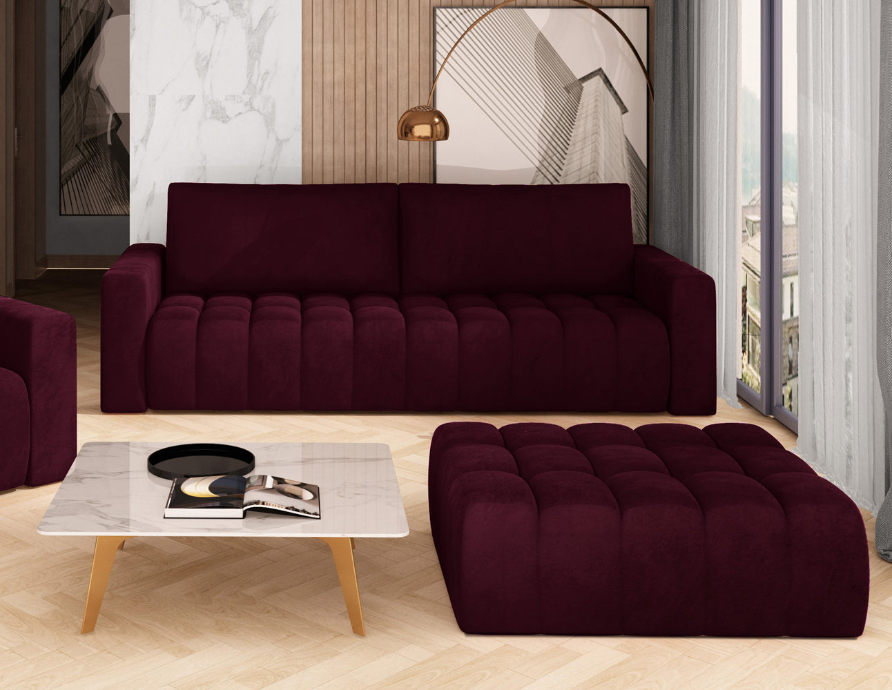 Bordowa pufa Lazaro Matt Velvet 68 ustawiona w eleganckim salonie obok stolika kawowego i kanapy, na tle ozdobnej ściany.