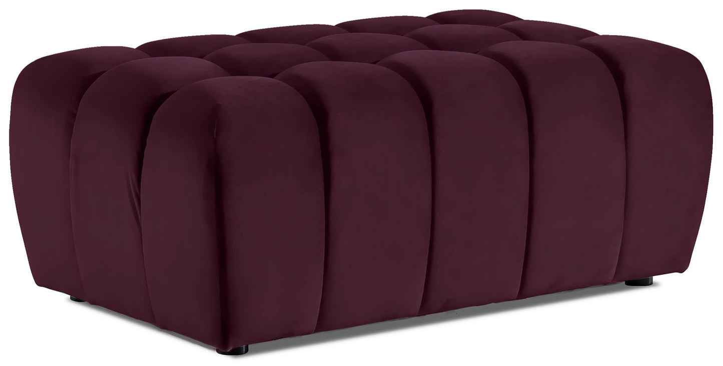 Prostokątna pufa Lazaro obita aksamitnym welurem Matt Velvet 68 w głębokim bordowym kolorze, z charakterystycznymi pionowymi, zaokrąglonymi przetłoczeniami, sfotografowana na czystym białym tle.
