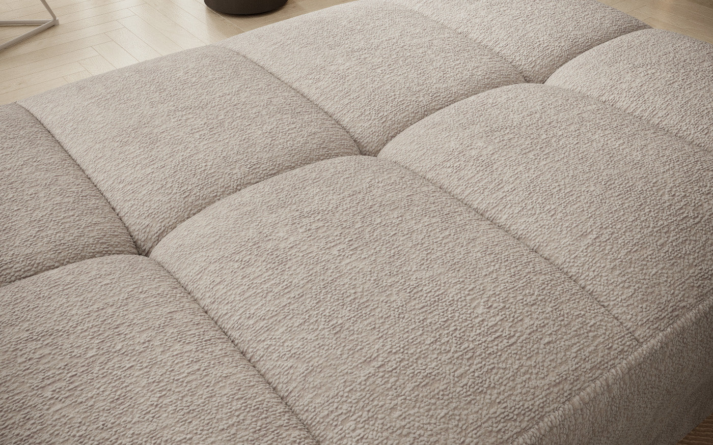 Pufa do siedzenia, prostokątna, jasnobeżowa z przeszyciami.