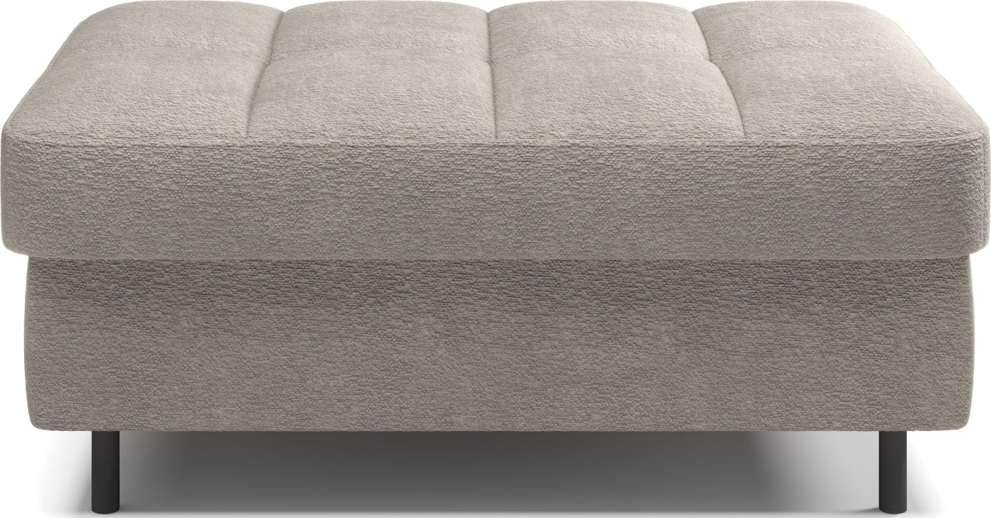 Pufa na białym tle, prostokątna, jasnobeżowa z przeszyciami.