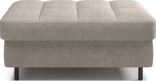 Pufa na białym tle, prostokątna, jasnobeżowa z przeszyciami.