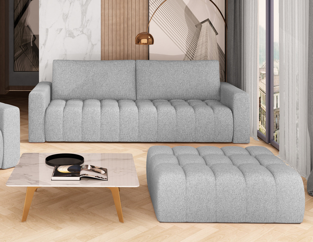 Pufa Lazaro w kolorze Grande 81 jasnoszary jako stolik kawowy w nowoczesnym salonie, dopasowana stylistycznie do sofy Lazaro i jasnego, drewnianego parkietu.