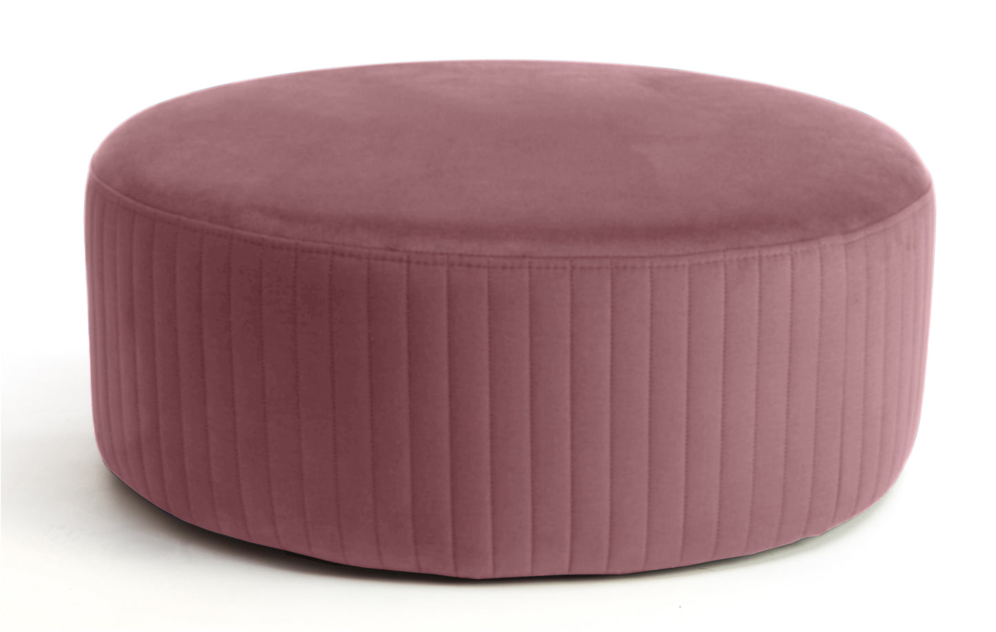 Pufa Lara w kolorze Mat Velvet 63 różowy, okrągła, tapicerowana tkaniną welurową z pionowym przeszyciem po bokach, prezentowana na białym tle.