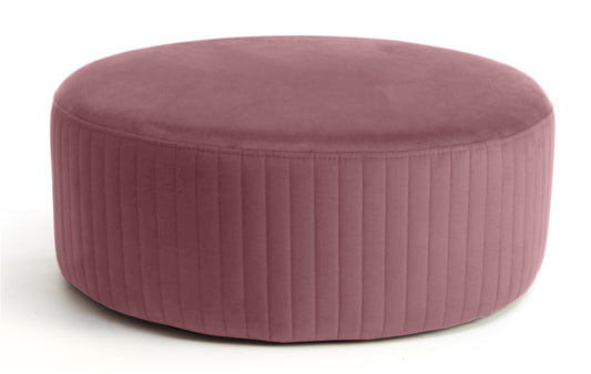 Pufa Lara w kolorze Mat Velvet 63 różowy, okrągła, tapicerowana tkaniną welurową z pionowym przeszyciem po bokach, prezentowana na białym tle.