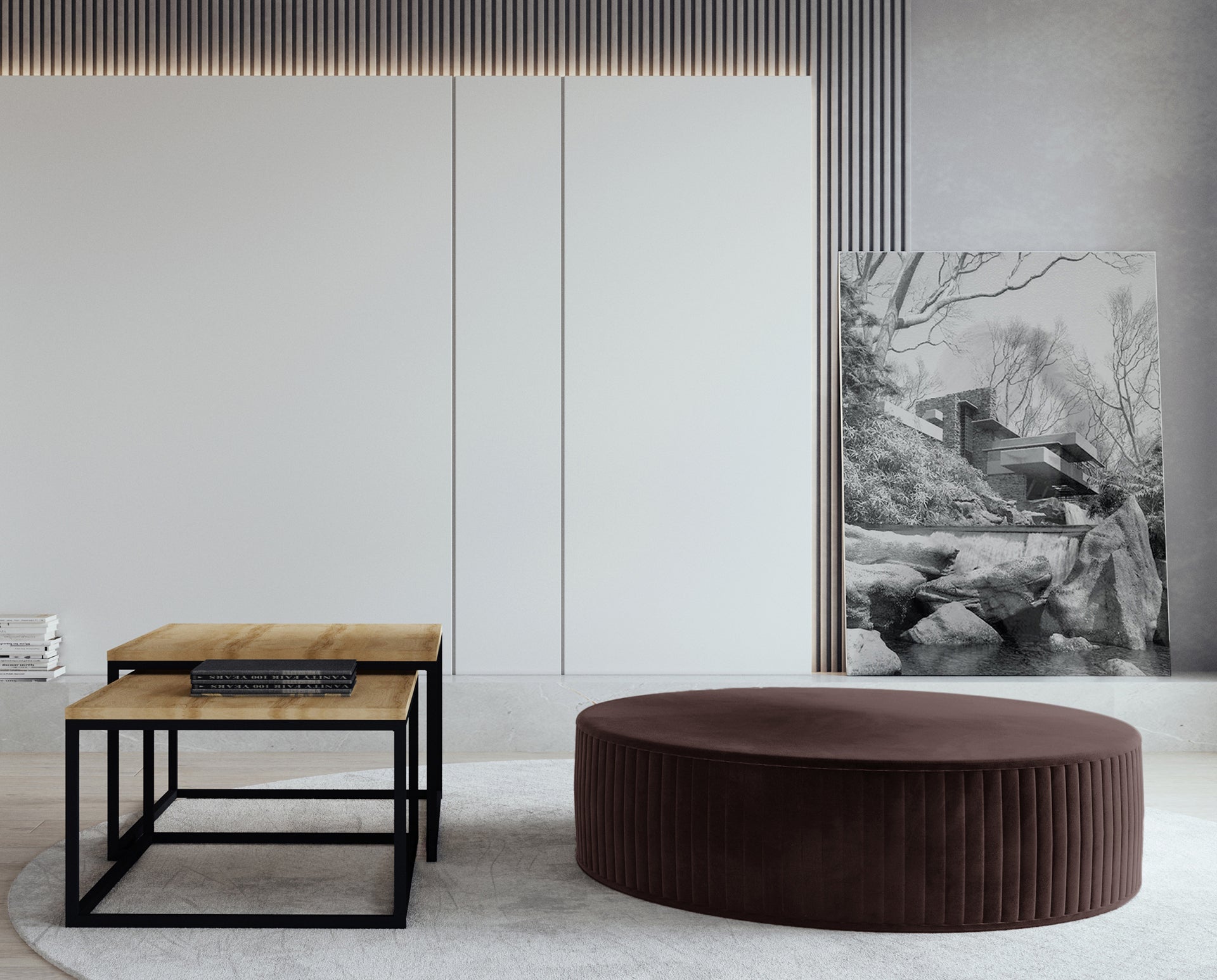 Pufa Lara w kolorze Monolith 29 brązowy, ustawiona w nowoczesnym salonie na jasnym dywanie, obok zestawu stolików kawowych z drewnianym blatem i czarną metalową podstawą.