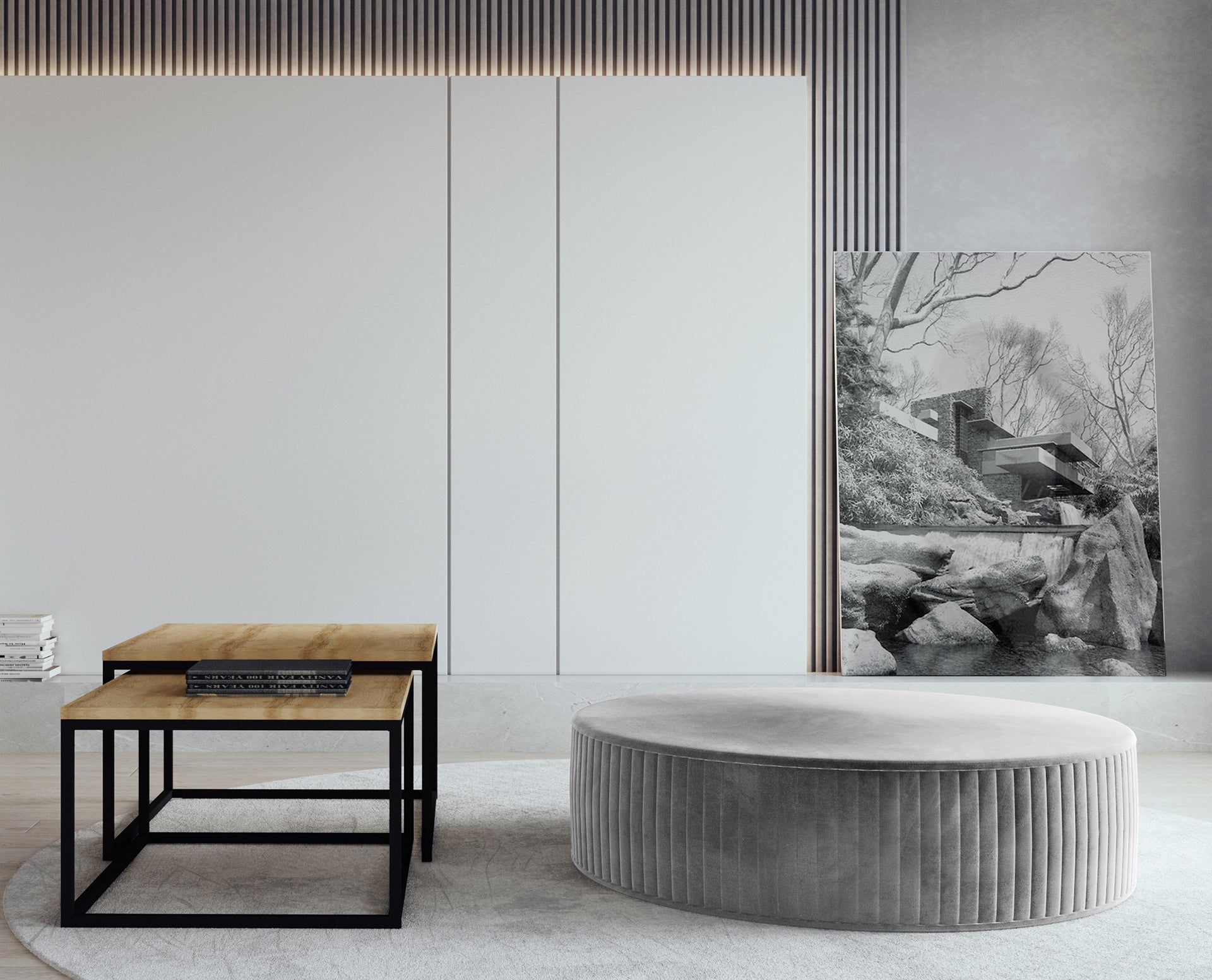 Pufa Lara w kolorze Monolith 84 jasnoszary, ustawiona w nowoczesnym salonie na jasnym dywanie, obok stolików kawowych z drewnianym blatem i czarną metalową podstawą.