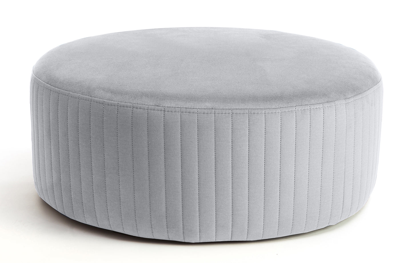 Pufa Lara w kolorze Monolith 84 jasnoszary, okrągła, tapicerowana welurem z pionowym przeszyciem po bokach, prezentowana na białym tle.