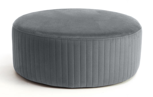 Pufa Lara w kolorze Monolith 85 szary, okrągła, tapicerowana tkaniną welurową z pionowym przeszyciem po bokach, prezentowana na białym tle.