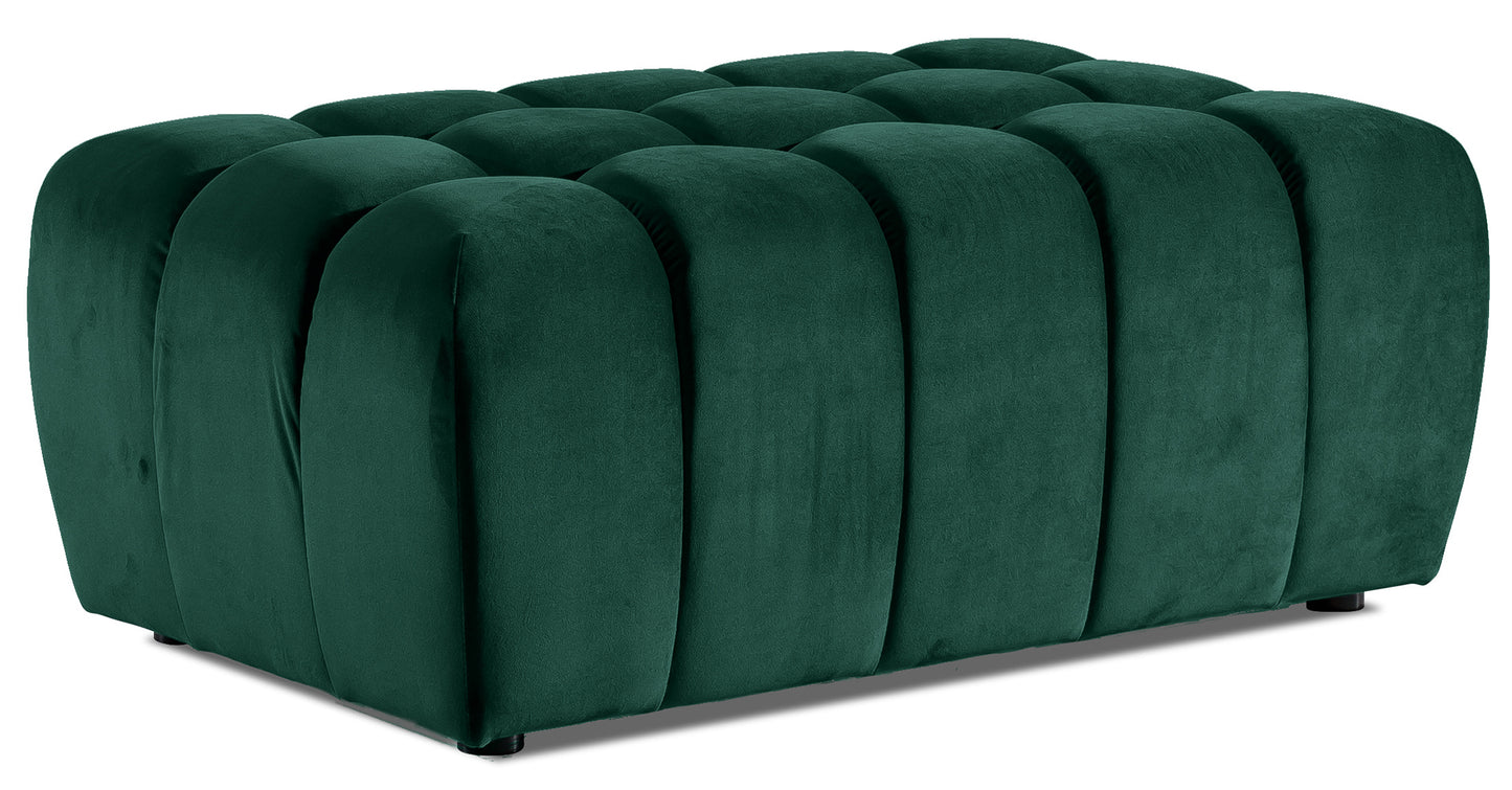 Pufa Lazaro Monolith 37 zielona, widok 3/4: prostokątna pufa obita miękkim, butelkowozielonym aksamitem z charakterystycznym pionowym pikowaniem w zaokrąglone pasy.