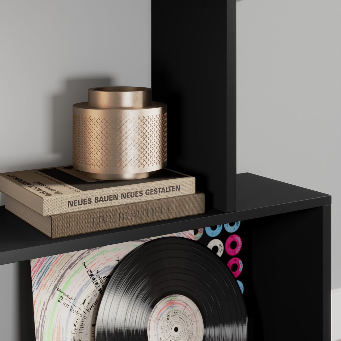 Półka czarnego regału Evertti z ozdobnym metalowym wazonem i książkami na temat designu – elegancki detal wnętrza.