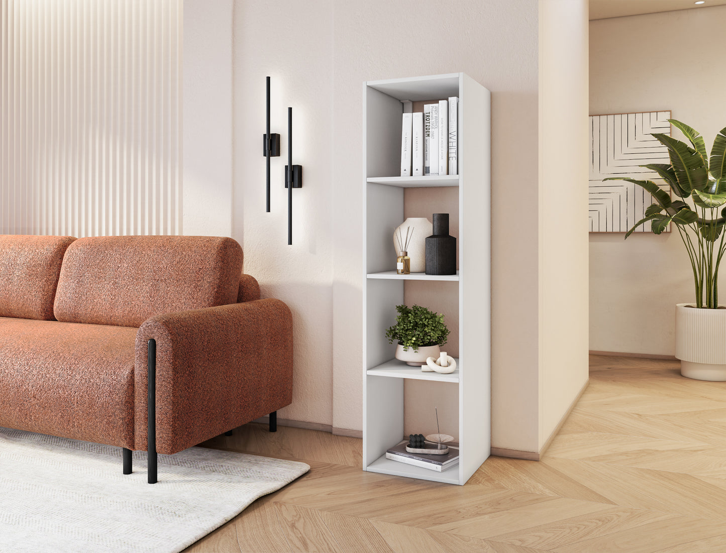 Biały regał Figgi w eleganckim salonie, ustawiony przy ścianie obok sofy, wypełniony książkami i dekoracjami.