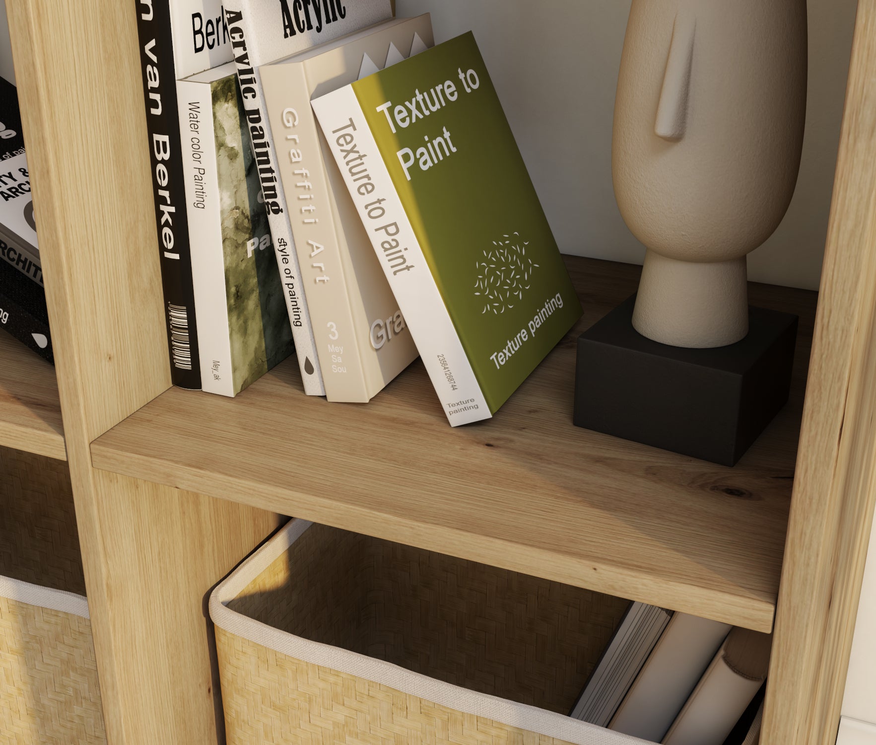 Zbliżenie na półkę regału Jugis w kolorze dąb artisan, z książkami o sztuce i rzeźbą dekoracyjną obok wiklinowego kosza.