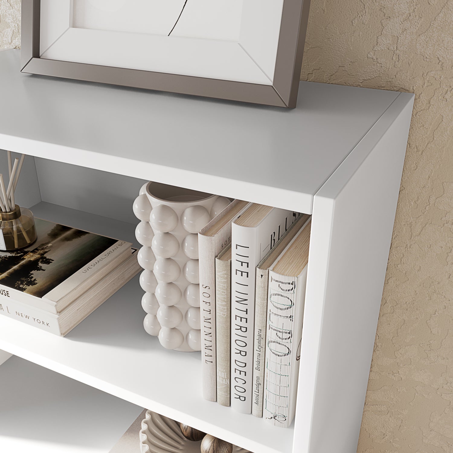 Nowoczesny regał Pocett w białym kolorze z książkami i dekoracją, idealny do salonu lub biura w stylu minimalistycznym i skandynawskim.