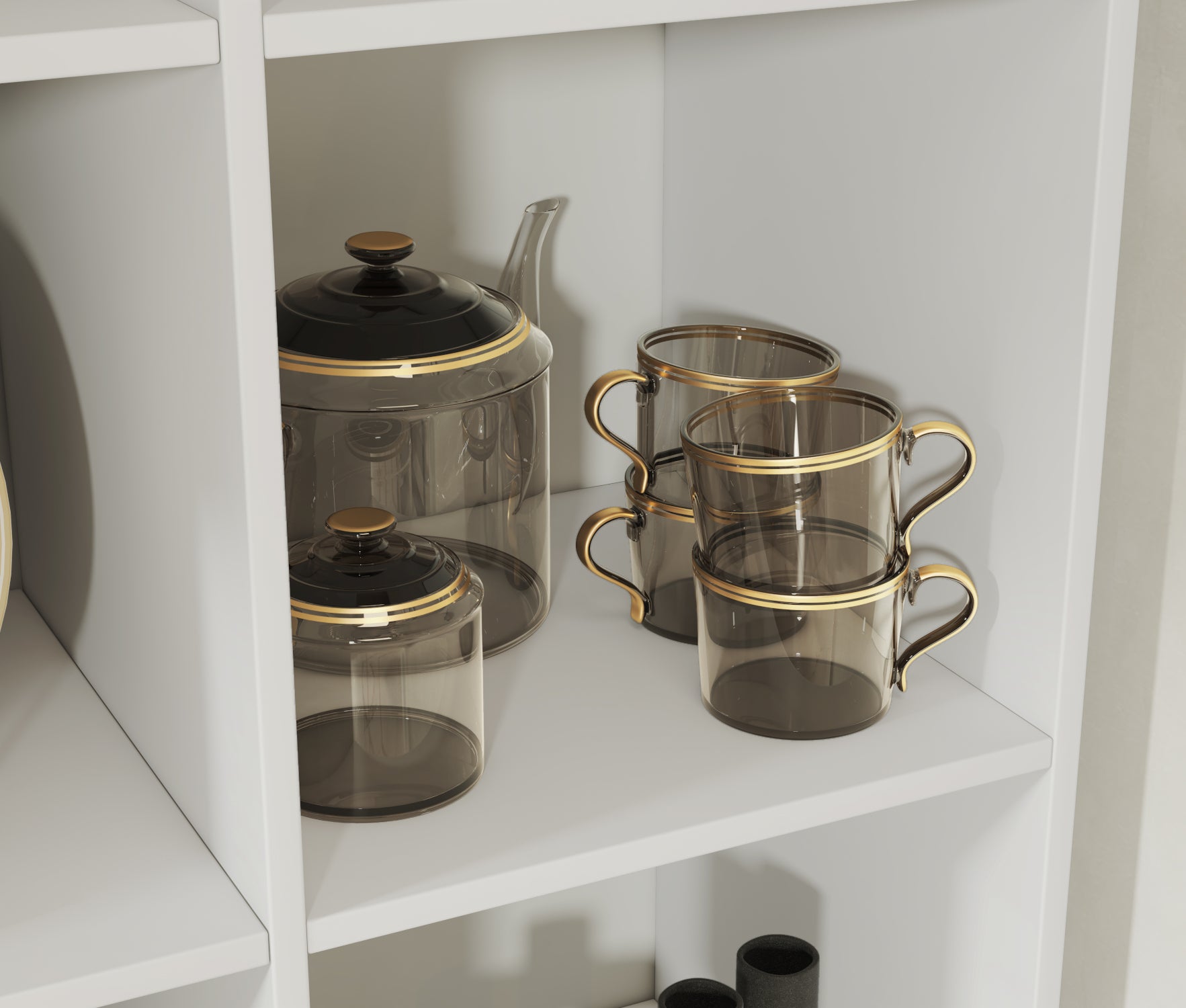 Zbliżenie na biały regał Postto z eleganckim zestawem do herbaty – szklany dzbanek i filiżanki ze złotym rantem w nowoczesnej kuchni.