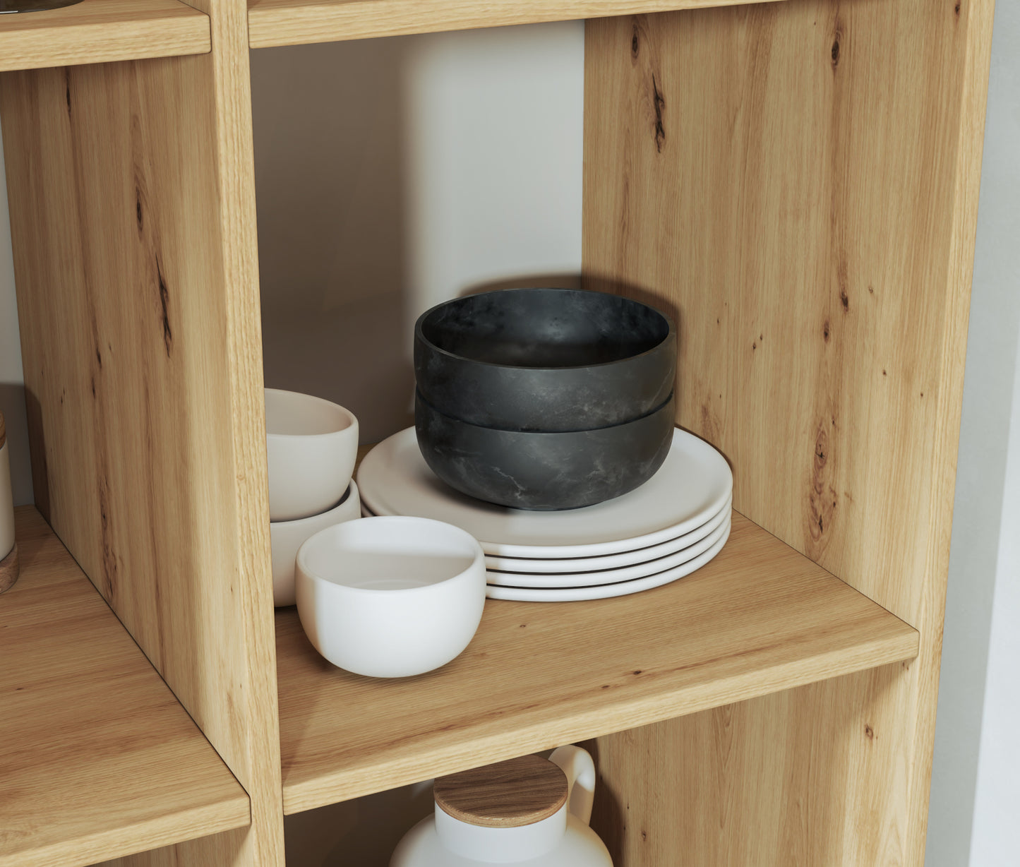 Zbliżenie na półkę regału Postto dąb artisan z elegancką ceramiką – czarne miski i białe talerze w nowoczesnej, naturalnej aranżacji.