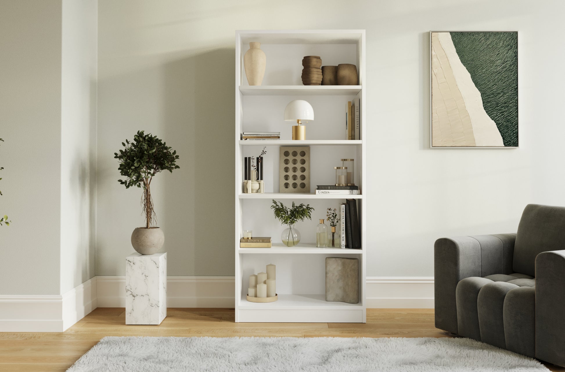 Biały regał Seilf z pięcioma półkami w nowoczesnym salonie, obok donicy z rośliną, szarej sofy i obrazu z motywem plaży. 