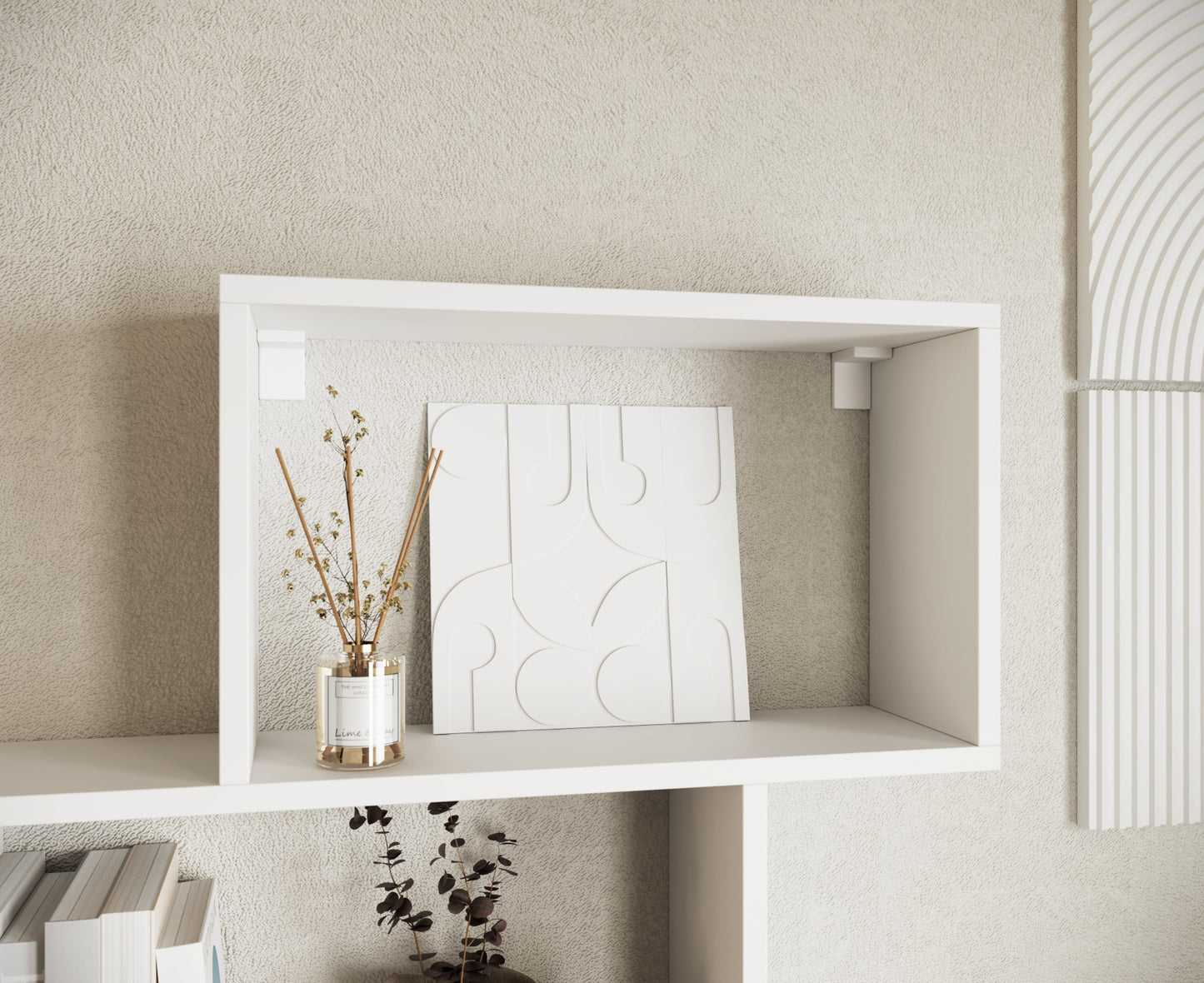 Zbliżenie na górny segment białego regału Shellf z dekoracyjnym panelem i dyfuzorem zapachowym na jasnej strukturze ściany.