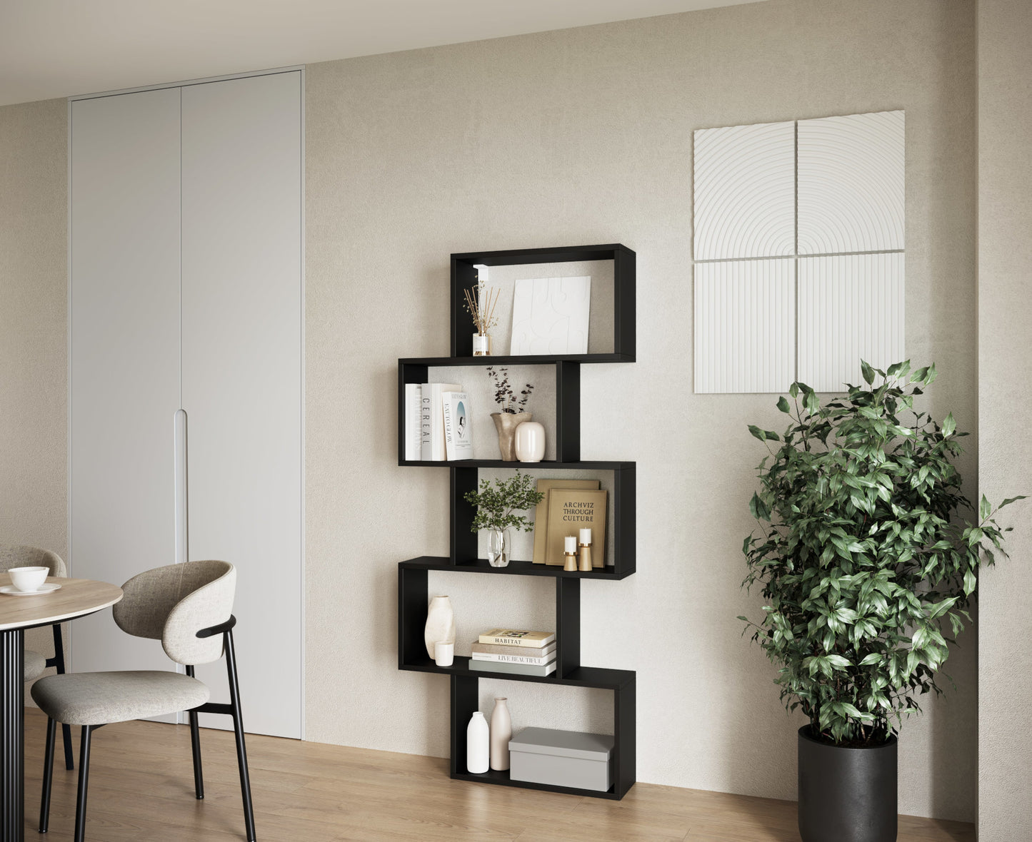 Czarny regał Shellf w salonie, z asymetrycznymi półkami udekorowanymi książkami, wazonami i świecami, ustawiony przy jasnej ścianie.