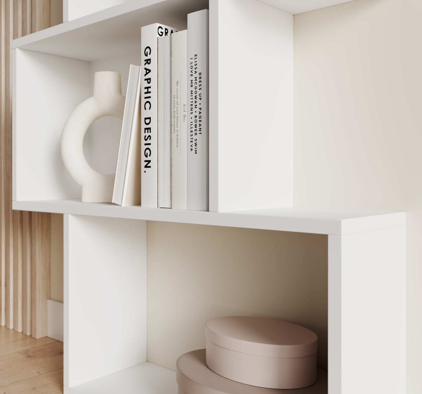 Nowoczesny biały regał Sottis z książkami o designie i rzeźbą ceramiczną – stylowy akcent do jasnych, minimalistycznych wnętrz.