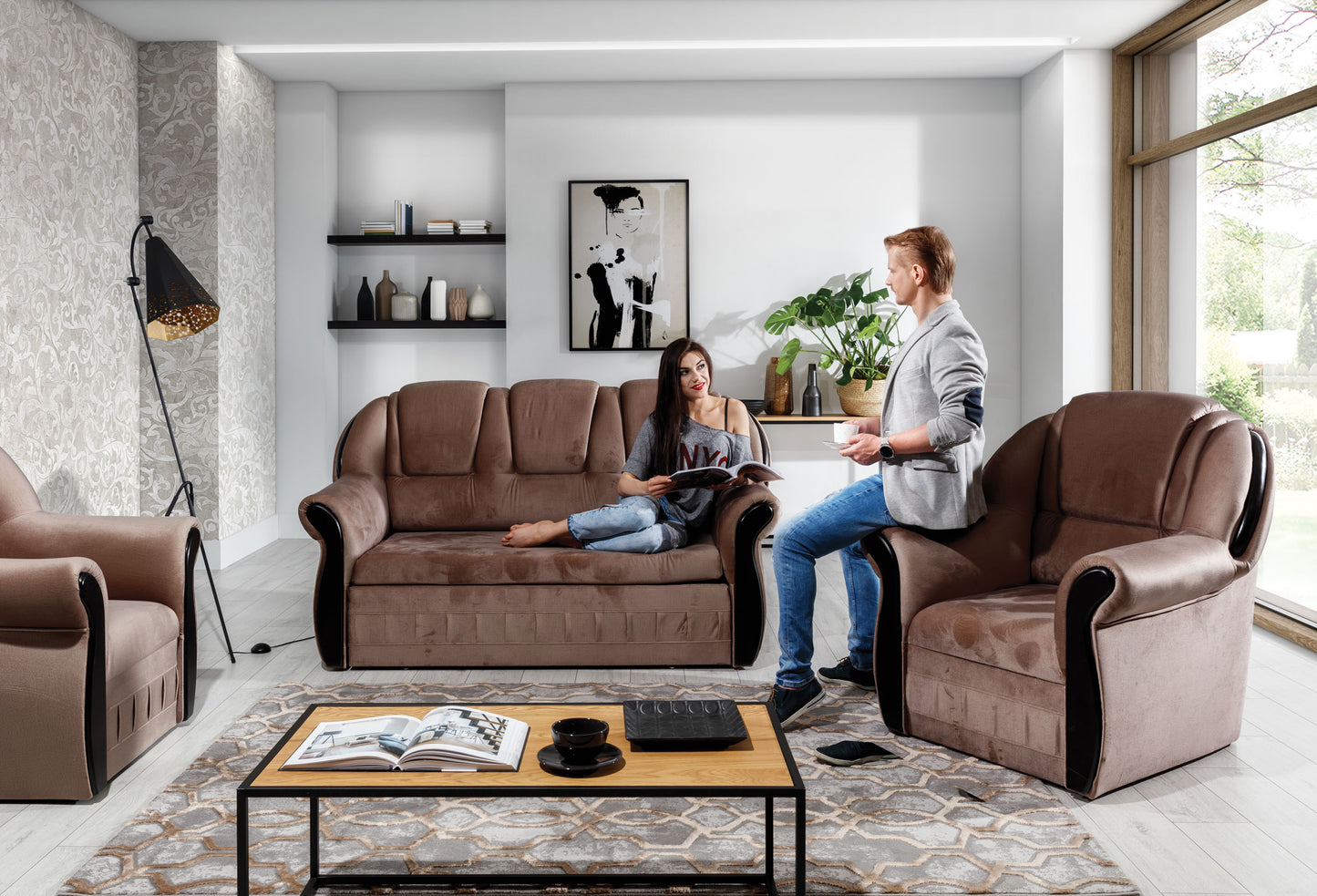 Sofa dwuosobowa i fotel Lord Monolith 09 w kolorze cappuccino ustawione przy stolikach kawowych na wzorzystym dywanie. Wyraźna faktura materiału i masywne podłokietniki tworzą solidny wizualnie zestaw.