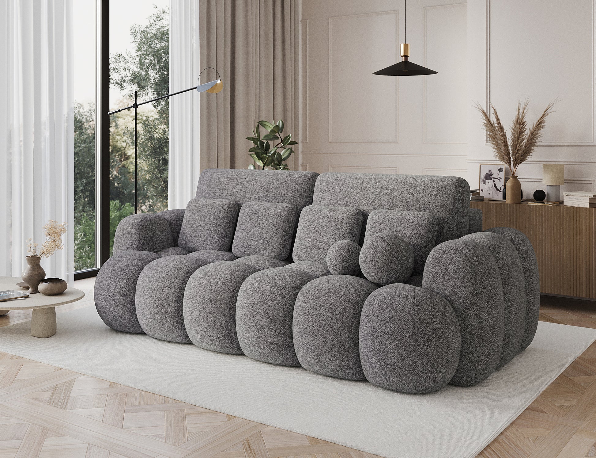 Big Sofa Cotonn w tkaninie Paolli 04 szary, ustawiona w eleganckim salonie, z dużymi poduchami i zaokrąglonymi bokami.