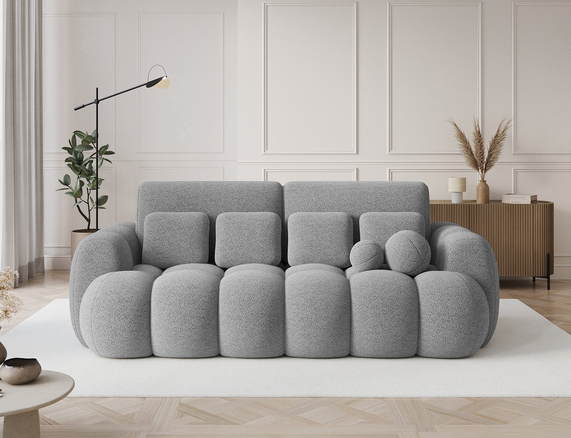 Big sofa Cotonn w tkaninie Royal 04 szary w eleganckim wnętrzu, ustawiona na jasnym dywanie w stylowym salonie.