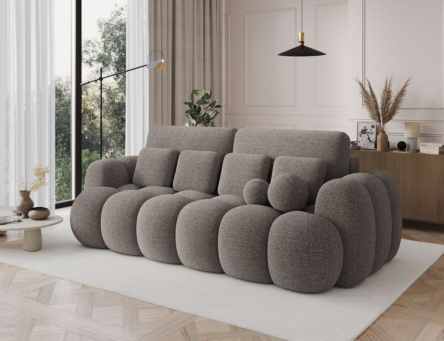 Sofa Cotonn Royal 20 w kolorze beżowym – ustawiona w eleganckim salonie, ukazana pod kątem, z dekoracyjnymi poduchami i zaokrąglonymi formami.
