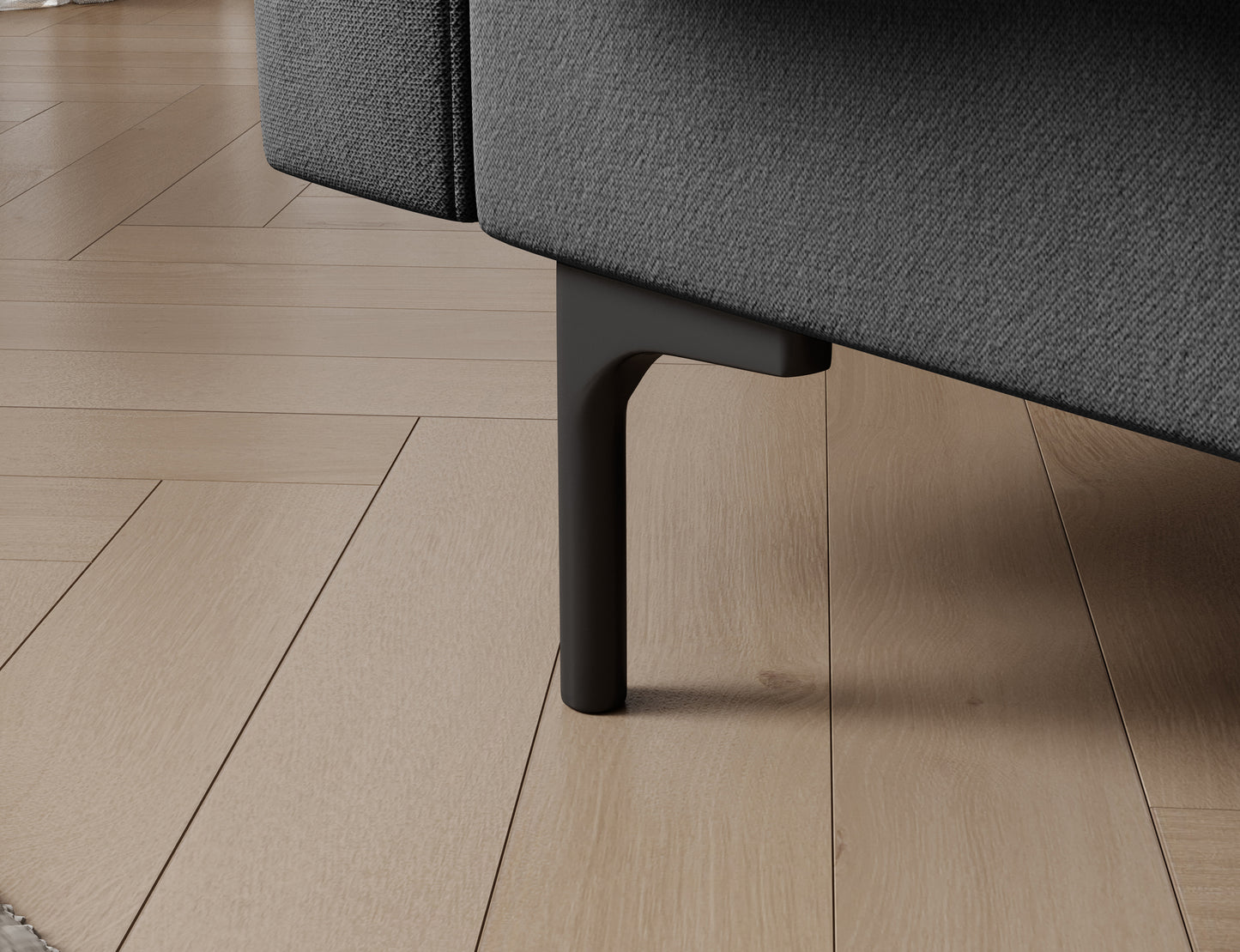 Detal czarnej nóżki wersalki Roneyy Sola 06 szarej – stabilna, smukła konstrukcja ułatwiająca sprzątanie pod meblem i wokół niego.