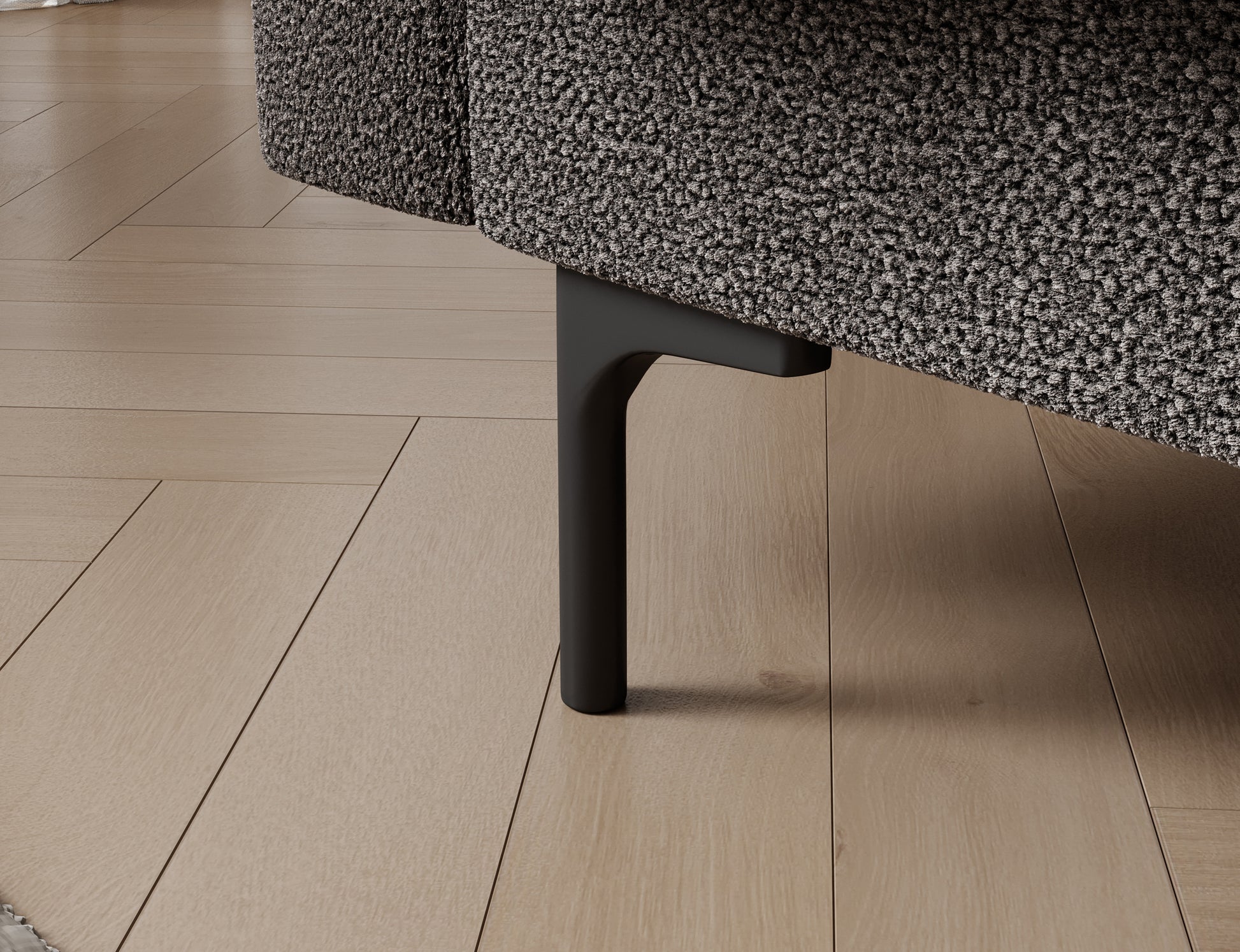 Zbliżenie na plastikową nóżkę sofy Roneyy w tkaninie Xillar 04 szary – nowoczesny, subtelny detal konstrukcyjny.