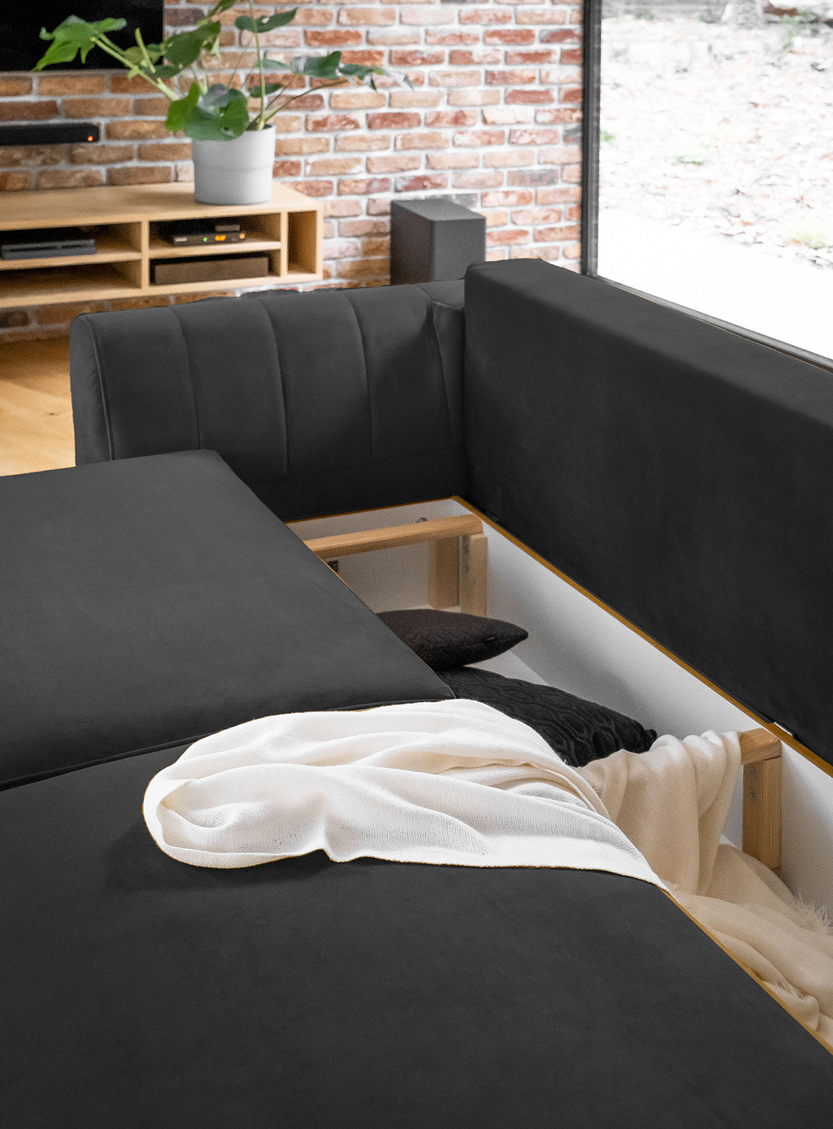 Sofa z fotelem i pufą Megis Nube w ciemnoszarej tapicerce prezentuje nowoczesny styl. Minimalistyczny design podkreśla estetykę wnętrza.
